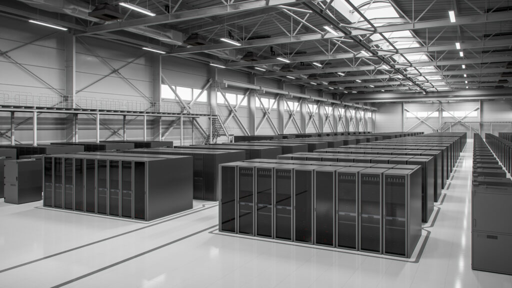Rows of black server cabinets on a white floor inside a large, high-ceilinged data center hall
